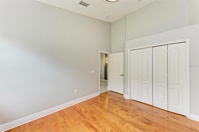 6423 Royal Tern Cir, Lakewood Ranch, FL 34202 - unfurnished bedroom with a towering ceiling, light wood-style floors, and a closet