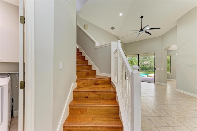 6423 Royal Tern Cir, Lakewood Ranch, FL 34202 - staircase featuring washer / clothes dryer, a ceiling fan, arched walkways, tile patterned flooring, and high vaulted ceiling