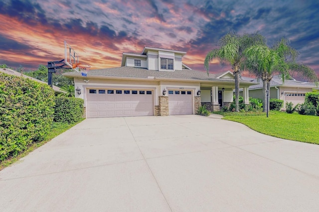 6423 Royal Tern Cir, Lakewood Ranch, FL 34202 - view of front facade featuring a garage, a porch, driveway, a lawn, and stone siding