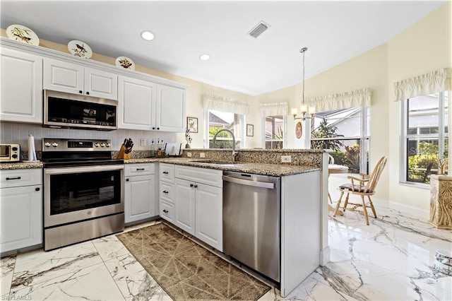 3760 Gloxinia Dr, North Fort Myers, FL 33917 - kitchen featuring stainless steel appliances, a sink, light marble finish floors, a chandelier, and a peninsula