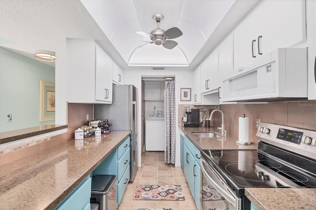 6832 Woodwind Dr Unit 53, Sarasota, FL 34231 - kitchen with electric stove, blue cabinetry, white microwave, a tray ceiling, and white cabinetry
