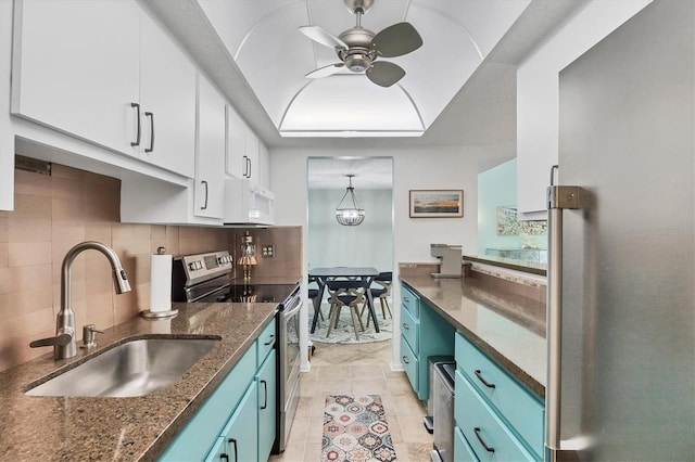 6832 Woodwind Dr Unit 53, Sarasota, FL 34231 - kitchen with stainless steel appliances, blue cabinetry, white cabinetry, ceiling fan, and a raised ceiling