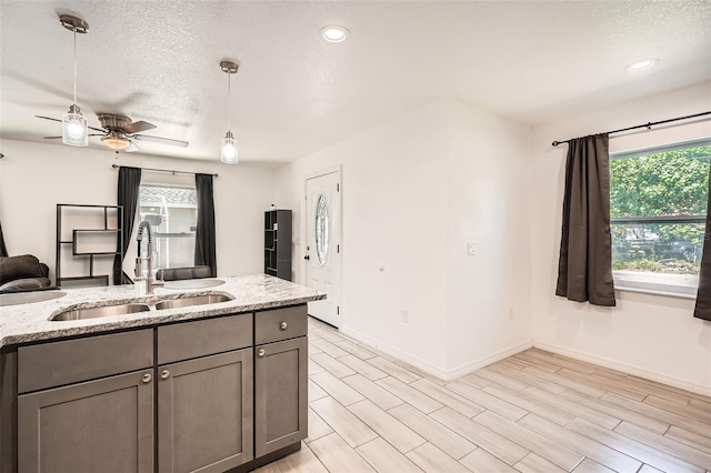 718 17th St E, Bradenton, FL 34208 - kitchen featuring a textured ceiling, hanging light fixtures, light stone counters, ceiling fan, and gray cabinets