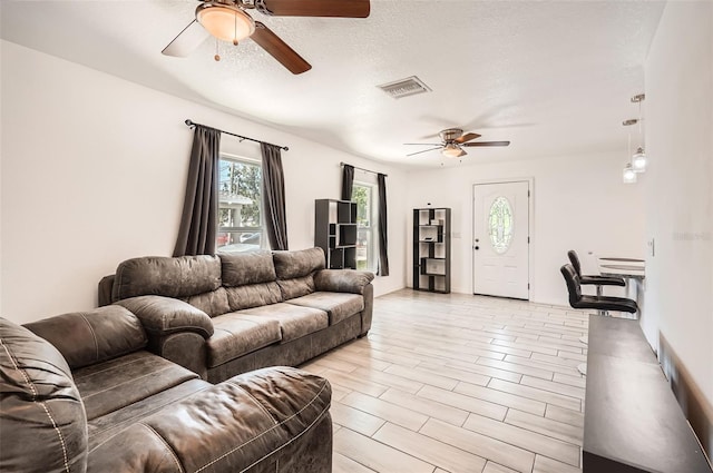 718 17th St E, Bradenton, FL 34208 - living room with a ceiling fan, a textured ceiling, and light wood-style flooring