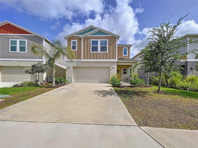 12832 Oak Hill Way, Parrish, FL 34219 - view of front of house with board and batten siding, a garage, and driveway