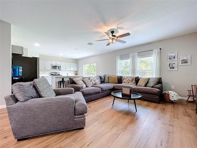 12832 Oak Hill Way, Parrish, FL 34219 - living room with light wood-style floors, ceiling fan, a textured ceiling, and recessed lighting