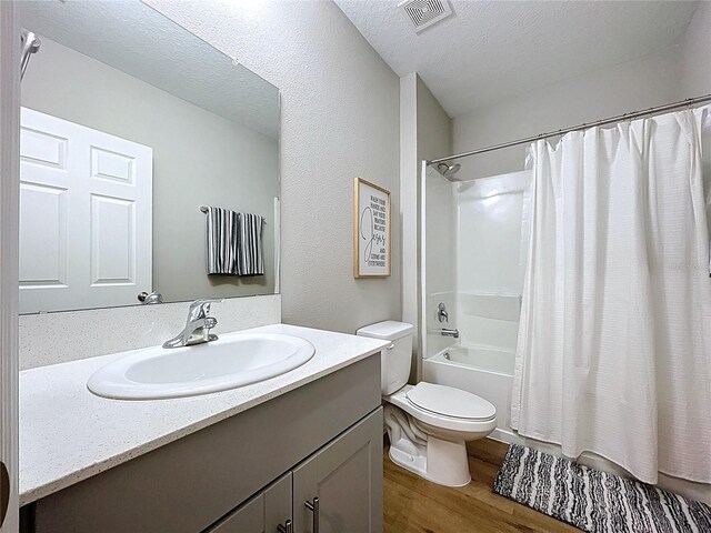 12832 Oak Hill Way, Parrish, FL 34219 - bathroom featuring wood finished floors, shower / tub combo with curtain, vanity, and a textured ceiling