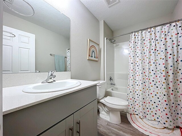 12832 Oak Hill Way, Parrish, FL 34219 - full bathroom featuring wood finished floors, vanity, a textured ceiling, and shower / tub combo