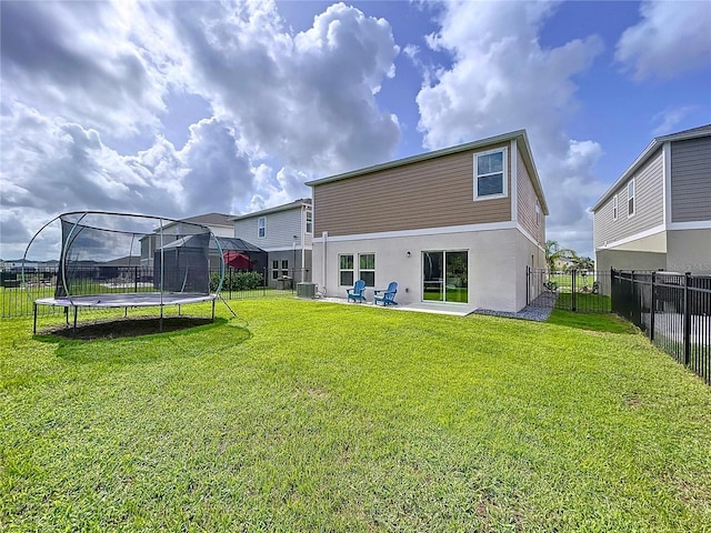 12832 Oak Hill Way, Parrish, FL 34219 - back of property with a trampoline, a fenced backyard, stucco siding, and a patio area