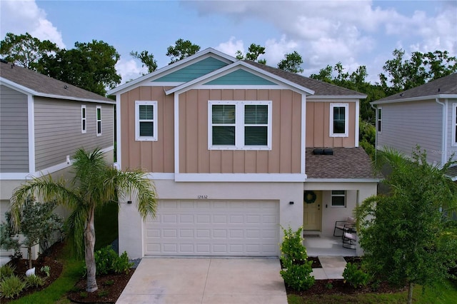 12832 Oak Hill Way, Parrish, FL 34219 - view of front of property featuring board and batten siding, an attached garage, driveway, and a shingled roof
