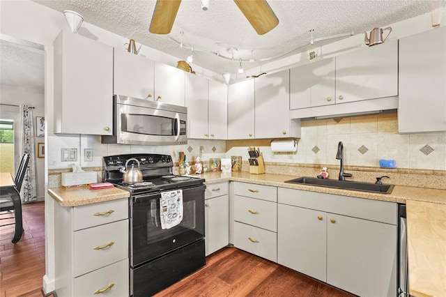20 Idle Sands Dr, Venice, FL 34293 - kitchen with stainless steel microwave, black / electric stove, a textured ceiling, light countertops, and dark wood-style flooring
