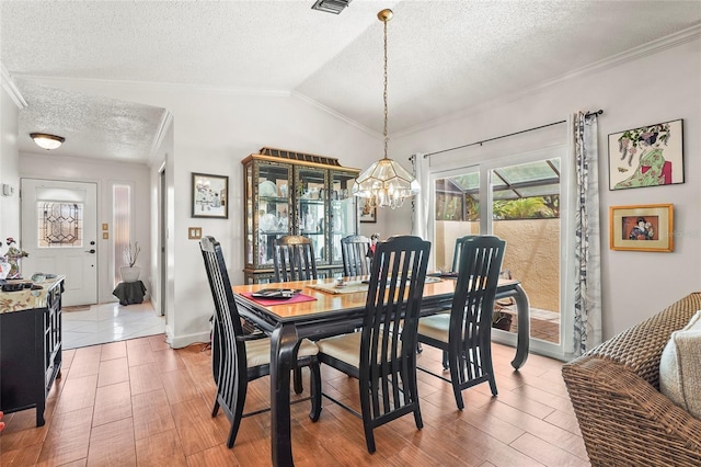 20 Idle Sands Dr, Venice, FL 34293 - dining room with a chandelier, a textured ceiling, lofted ceiling, ornamental molding, and light wood-style floors