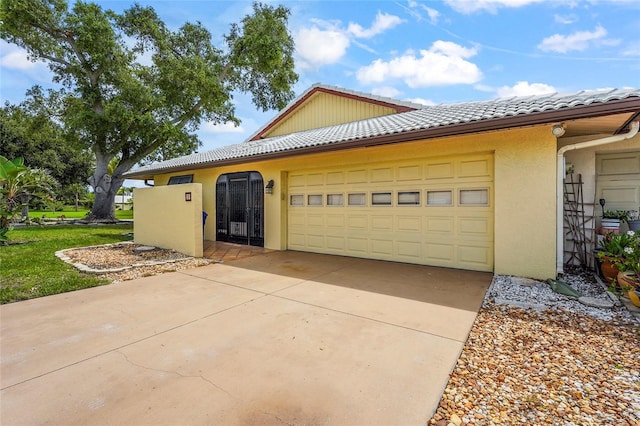 20 Idle Sands Dr, Venice, FL 34293 - view of side of home featuring a garage, driveway, a tile roof, and stucco siding