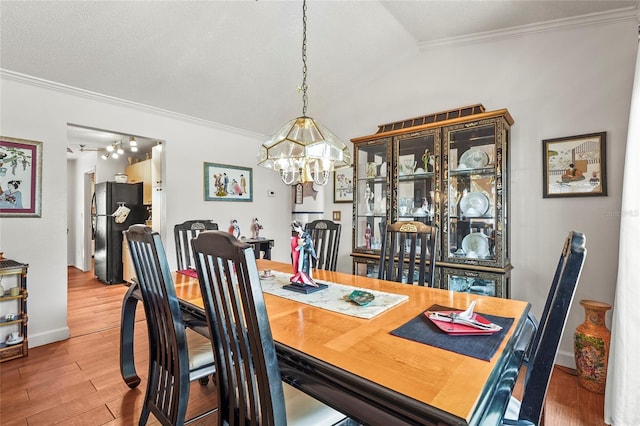 20 Idle Sands Dr, Venice, FL 34293 - dining space with crown molding, a chandelier, wood finished floors, and lofted ceiling