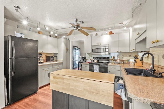 20 Idle Sands Dr, Venice, FL 34293 - kitchen with black appliances, a textured ceiling, ceiling fan, light wood-style flooring, and tasteful backsplash