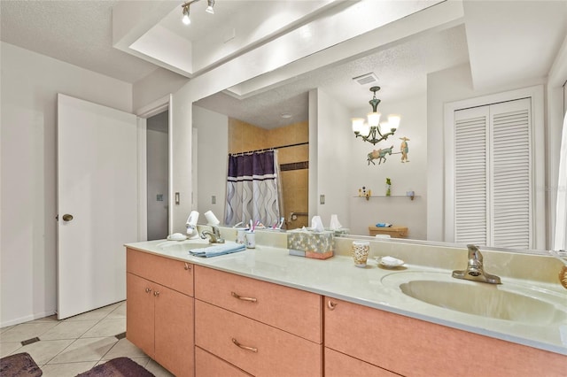 20 Idle Sands Dr, Venice, FL 34293 - bathroom with double vanity, a closet, tile patterned floors, a textured ceiling, and a chandelier