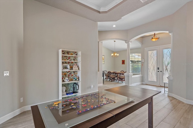5523 Secluded Oaks Way, Sarasota, FL 34233 - foyer with arched walkways, wood finished floors, decorative columns, french doors, and crown molding