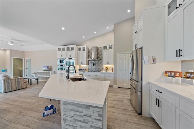 5523 Secluded Oaks Way, Sarasota, FL 34233 - kitchen featuring wall chimney range hood, a kitchen island with sink, light wood-style floors, stainless steel appliances, and recessed lighting