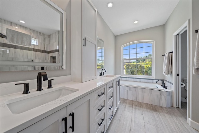 5523 Secluded Oaks Way, Sarasota, FL 34233 - full bathroom with a garden tub, double vanity, recessed lighting, a tile shower, and wood finished floors