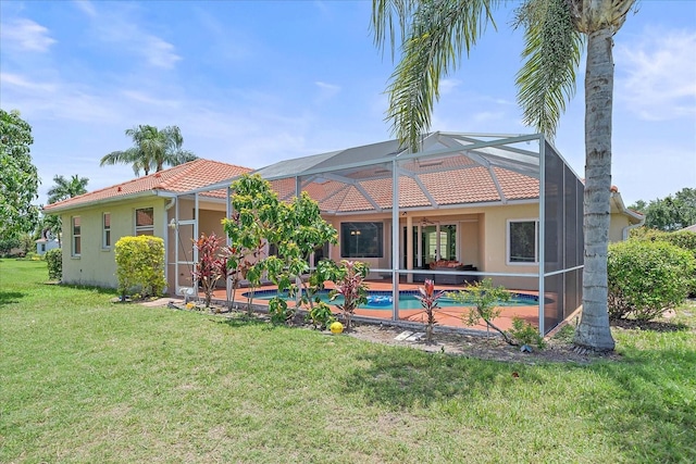 5523 Secluded Oaks Way, Sarasota, FL 34233 - back of property with a tile roof, a yard, an outdoor pool, stucco siding, and a patio area