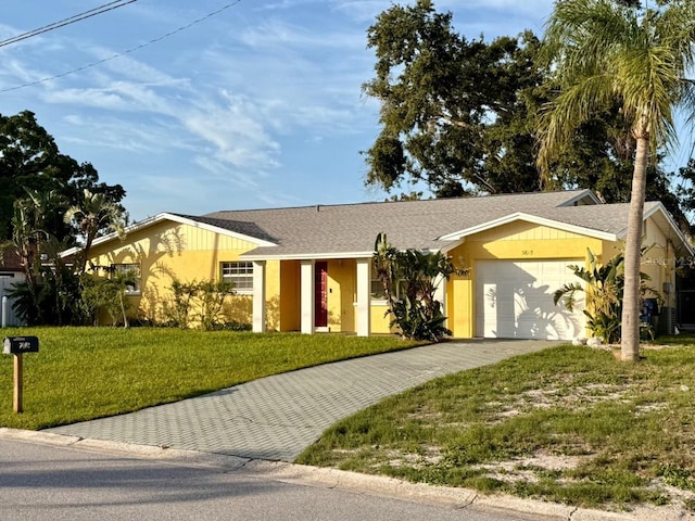 5615 Waneta Pl, Sarasota, FL 34231 - single story home featuring decorative driveway, a garage, a front yard, stucco siding, and a shingled roof