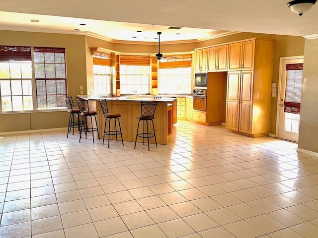 5615 Waneta Pl, Sarasota, FL 34231 - kitchen featuring crown molding, light tile patterned flooring, a kitchen breakfast bar, a peninsula, and healthy amount of natural light