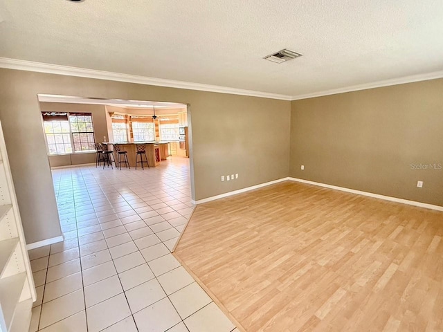 5615 Waneta Pl, Sarasota, FL 34231 - unfurnished room with crown molding, a textured ceiling, and light wood finished floors