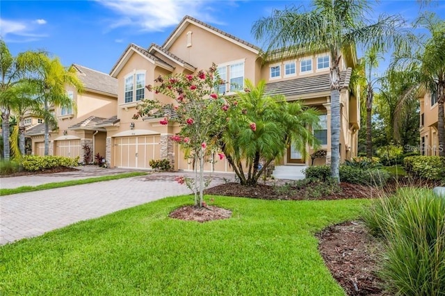 8168 Villa Grande Ct, Sarasota, FL 34243 - townhome / multi-family property with a garage, stucco siding, decorative driveway, and a front yard