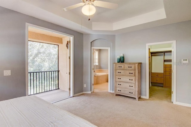 8168 Villa Grande Ct, Sarasota, FL 34243 - bedroom with a walk in closet, light colored carpet, a raised ceiling, access to outside, and ensuite bathroom