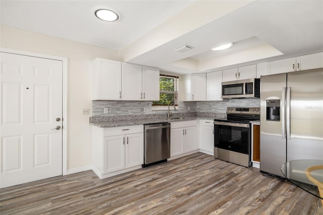 2513 Avenue B Ave B, Unit B, Bradenton Beach, FL 34217 - kitchen with stainless steel appliances, a tray ceiling, decorative backsplash, and white cabinets