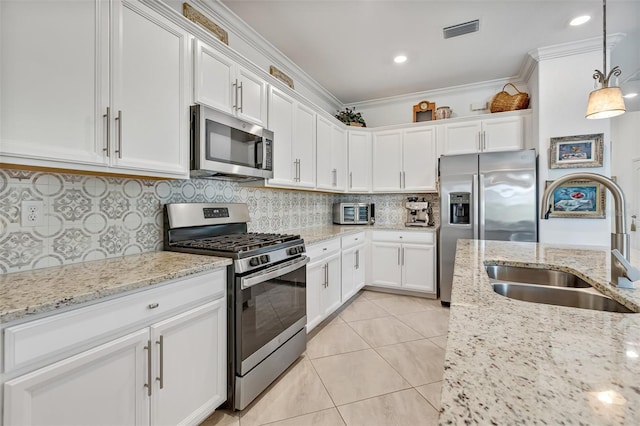 6507 Clairborne Ln, Bradenton, FL 34211 - kitchen with stainless steel appliances, white cabinetry, decorative backsplash, ornamental molding, and hanging light fixtures