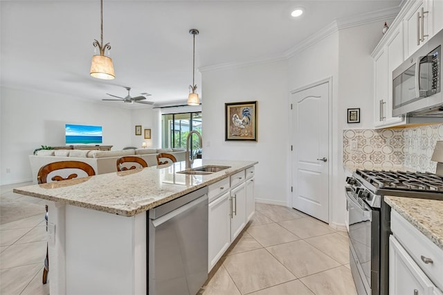 6507 Clairborne Ln, Bradenton, FL 34211 - kitchen with stainless steel appliances, a center island with sink, white cabinets, a breakfast bar area, and crown molding