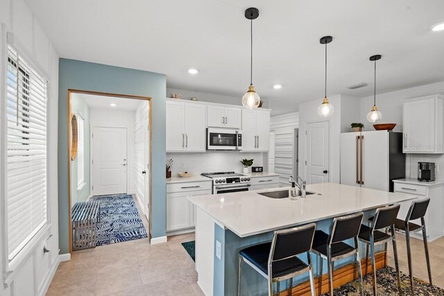 6563 Silverstar Dr, Sarasota, FL 34240 - kitchen with stainless steel appliances, a breakfast bar, backsplash, light countertops, and recessed lighting