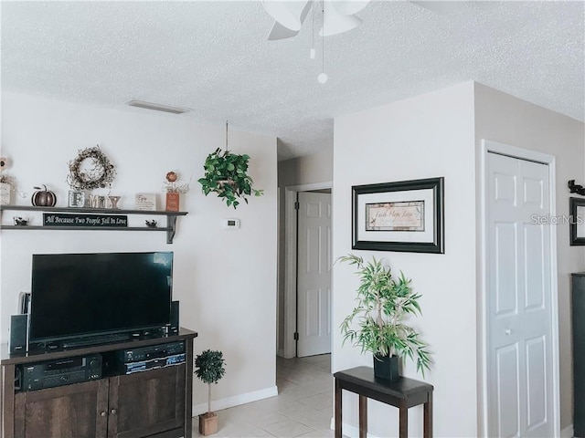 6004/6014 Deming Ave, North Port, FL 34287 - living room featuring a ceiling fan, a textured ceiling, light tile patterned floors, and baseboards
