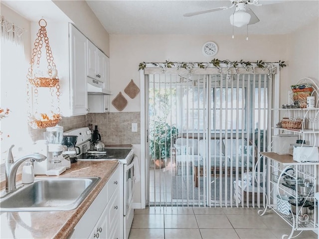 6004/6014 Deming Ave, North Port, FL 34287 - kitchen with white electric stove, under cabinet range hood, a sink, light tile patterned floors, and ceiling fan