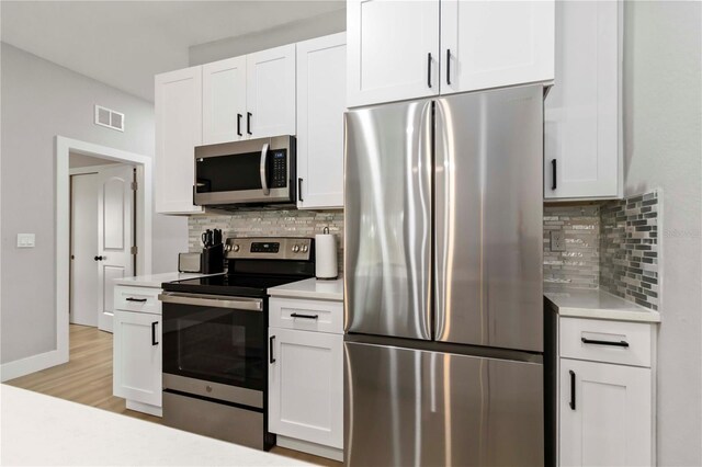 9417 Agate St, Port Charlotte, FL 33981 - kitchen with stainless steel appliances, light countertops, backsplash, and white cabinets