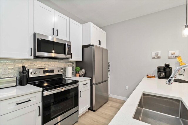 9417 Agate St, Port Charlotte, FL 33981 - kitchen with appliances with stainless steel finishes, a sink, light countertops, backsplash, and white cabinets