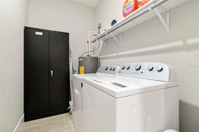 9417 Agate St, Port Charlotte, FL 33981 - washroom featuring separate washer and dryer, water heater, light wood-style flooring, baseboards, and a textured wall
