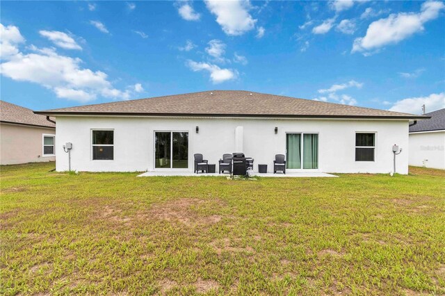 9417 Agate St, Port Charlotte, FL 33981 - rear view of house featuring stucco siding, a lawn, and a patio