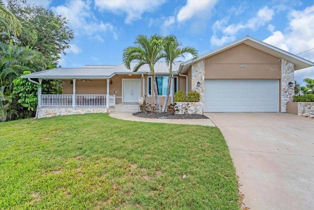 1461 Marlin St, Nokomis, FL 34275 - single story home featuring stone siding, a garage, concrete driveway, covered porch, and a front lawn