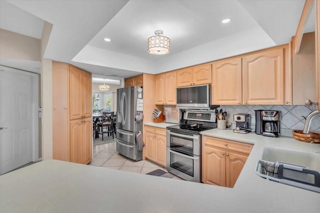 1461 Marlin St, Nokomis, FL 34275 - kitchen with stainless steel appliances, light brown cabinetry, tasteful backsplash, light tile patterned floors, and light countertops