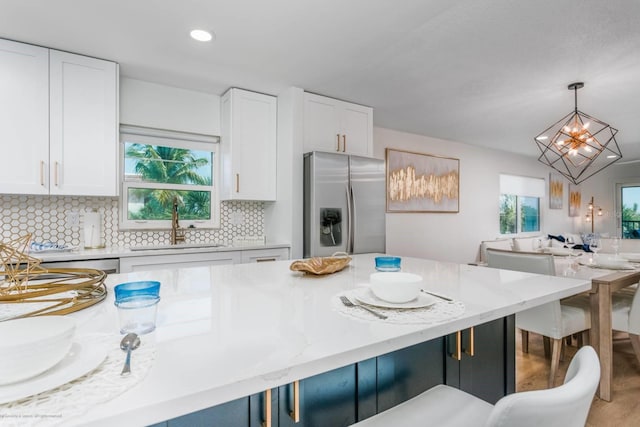 5600 Beach Way Dr Unit 315, Sarasota, FL 34242 - kitchen featuring stainless steel fridge, a sink, a chandelier, hanging light fixtures, and a kitchen breakfast bar