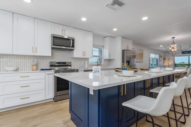 5600 Beach Way Dr Unit 315, Sarasota, FL 34242 - kitchen featuring appliances with stainless steel finishes, plenty of natural light, backsplash, white cabinets, and recessed lighting
