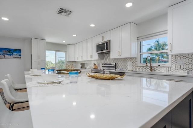 5600 Beach Way Dr Unit 315, Sarasota, FL 34242 - kitchen with appliances with stainless steel finishes, a sink, tasteful backsplash, white cabinetry, and recessed lighting