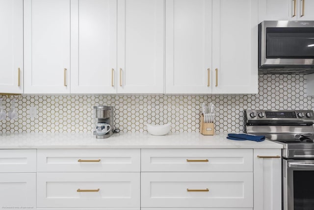 5600 Beach Way Dr Unit 315, Sarasota, FL 34242 - kitchen with stainless steel appliances, light countertops, white cabinets, and backsplash