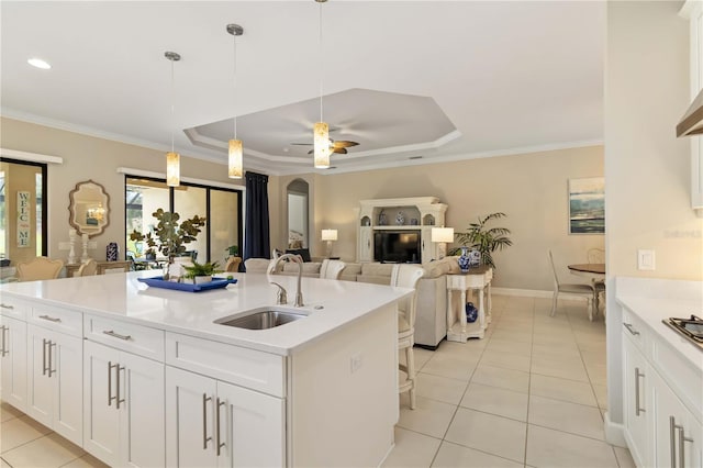 4540 Terrazza Ct, Bradenton, FL 34211 - kitchen featuring light tile patterned floors, light countertops, a tray ceiling, white cabinetry, and ornamental molding