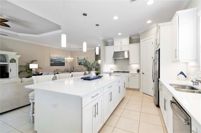 4540 Terrazza Ct, Bradenton, FL 34211 - kitchen with under cabinet range hood, stainless steel appliances, open floor plan, light tile patterned floors, and a breakfast bar area