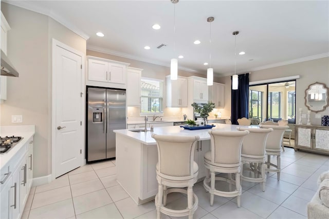4540 Terrazza Ct, Bradenton, FL 34211 - kitchen with appliances with stainless steel finishes, a center island with sink, crown molding, white cabinets, and light countertops