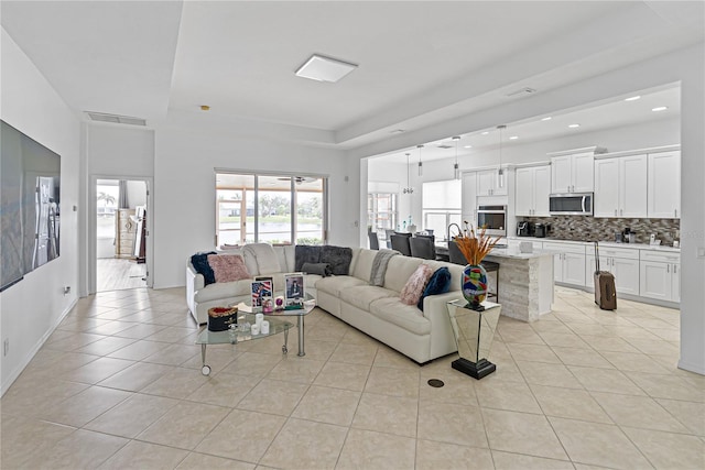 3671 Summerwind Cir, Bradenton, FL 34209 - living room with light tile patterned floors, recessed lighting, a tray ceiling, and baseboards