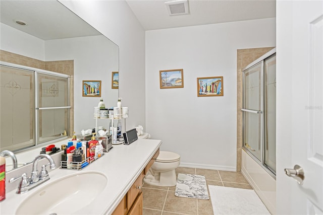 3671 Summerwind Cir, Bradenton, FL 34209 - bathroom with tile patterned floors, vanity, toilet, and bath / shower combo with glass door